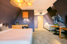 Overzicht van de deluxe studio met tweepersoons king size bed, keuken, tweepersoons zitje en extra bed.