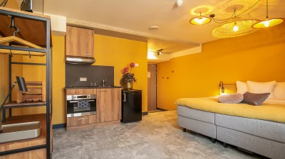 Overzicht van de familie kamer van Hotel Marktstad met bed, keuken en koelkast