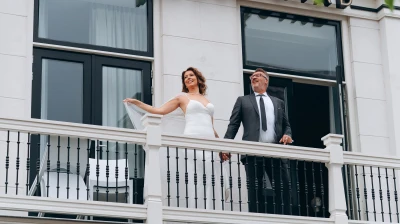 Net getrouwd stel geniet van uitzicht vanaf het balkon aan de voorzijde van Hotel Marktstad